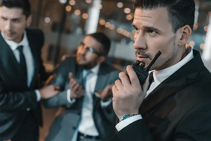 Business professionals in suits engaged in a discussion, emphasizing corporate security and executive protection training.